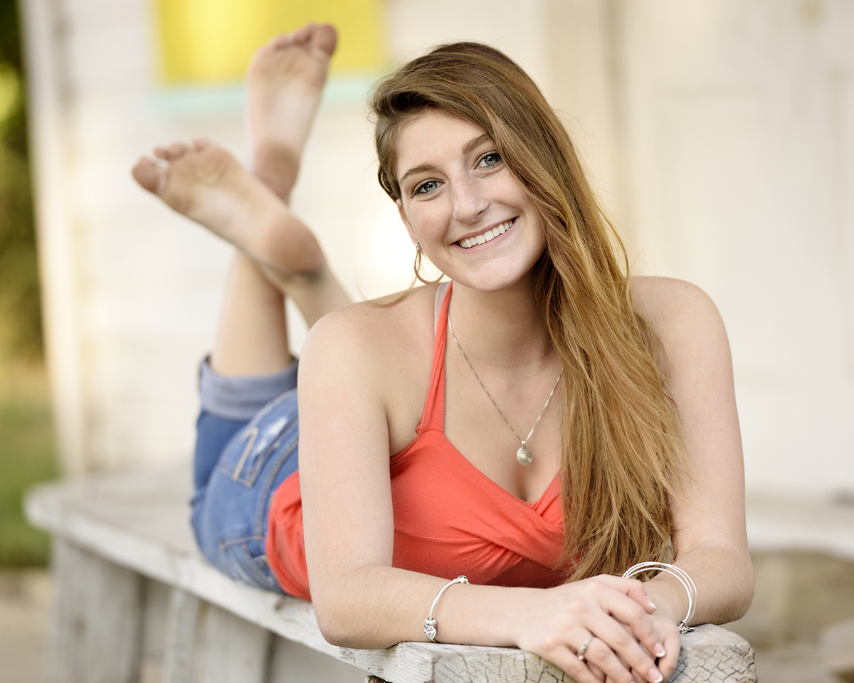 A cute girl posed for her high school senior picture.